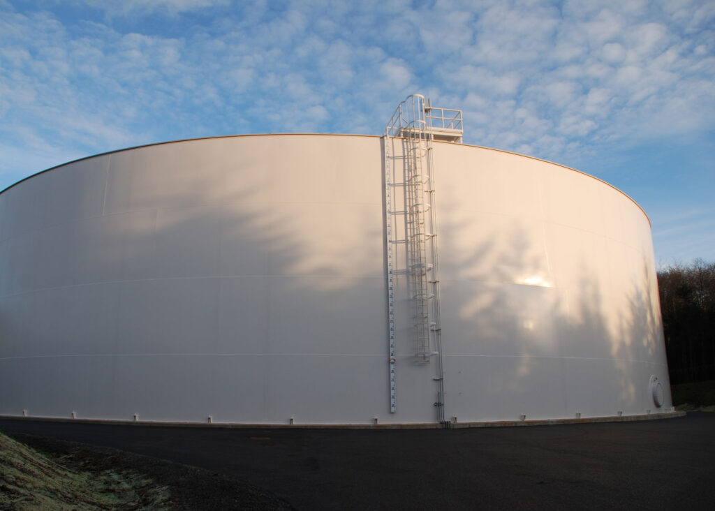 Welded steel ground level reservoir in grassy park. 