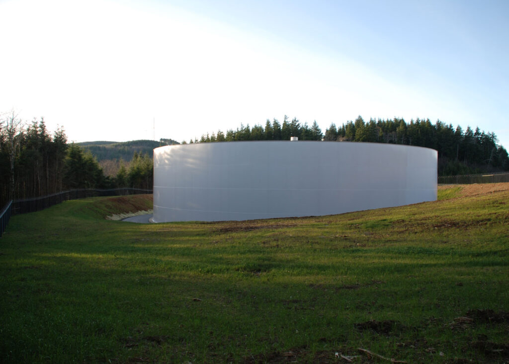 Welded steel ground level reservoir in grassy park. 